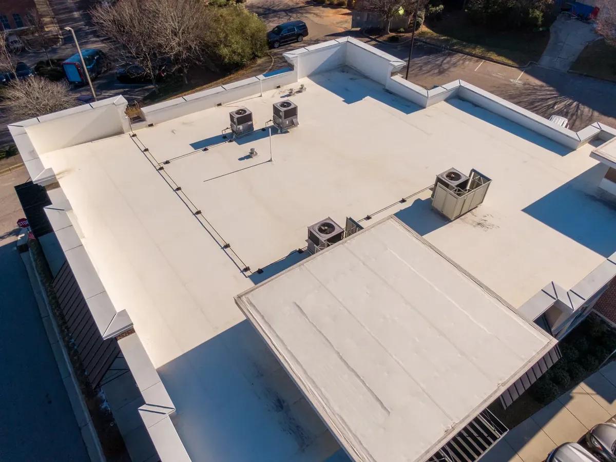 Aerial view of white single-ply membrane roofs on commercial buildings with rooftop HVAC units